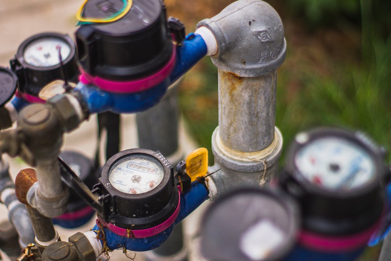 story-01 Detailed image of industrial water pressure gauges and pipes in an outdoor setting.