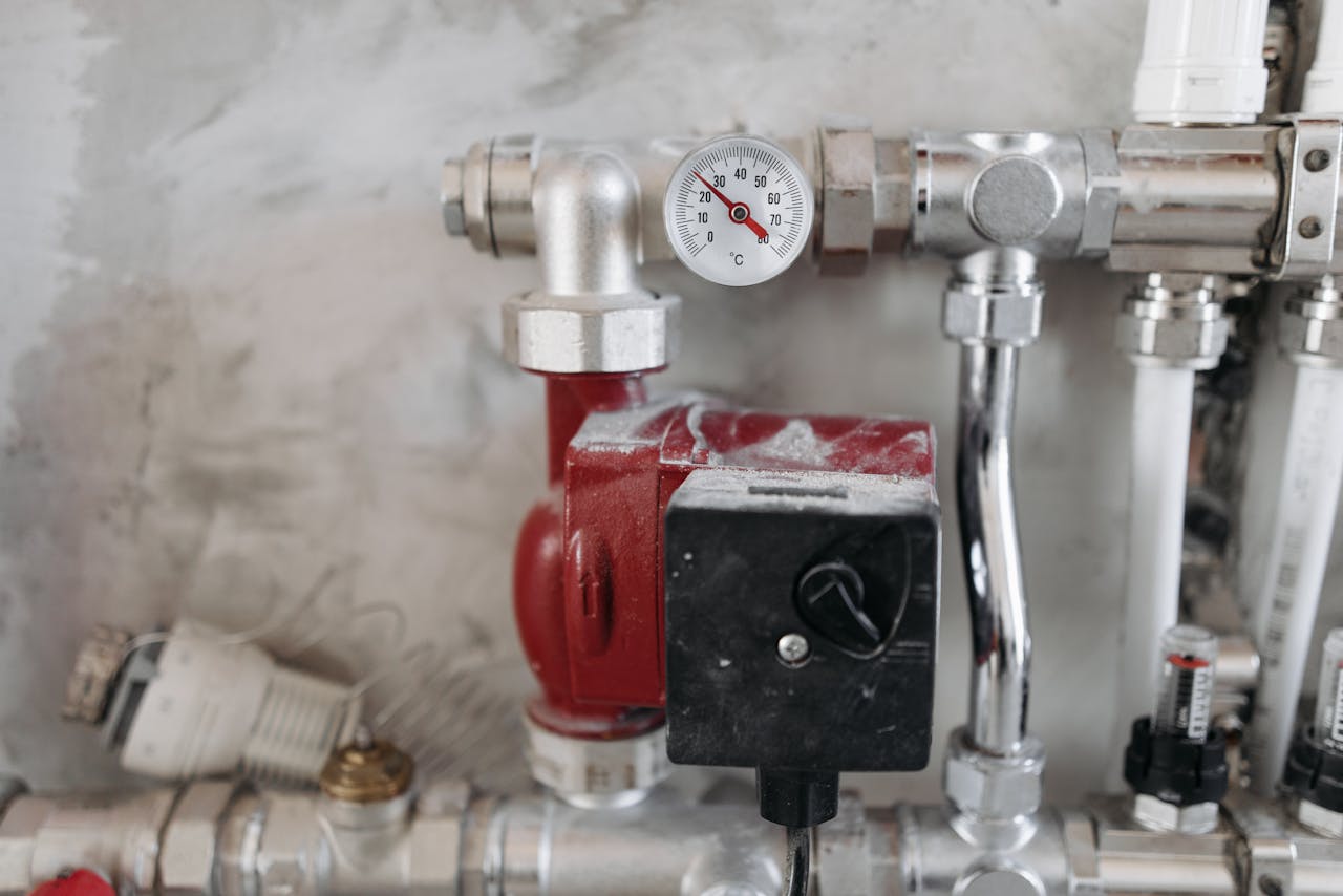 services-01 Close-up view of an industrial plumbing system featuring a pressure gauge and steel pipes.